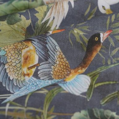 Pato Pájaro con plumaje colorido sobre un fondo de hojas verdes.